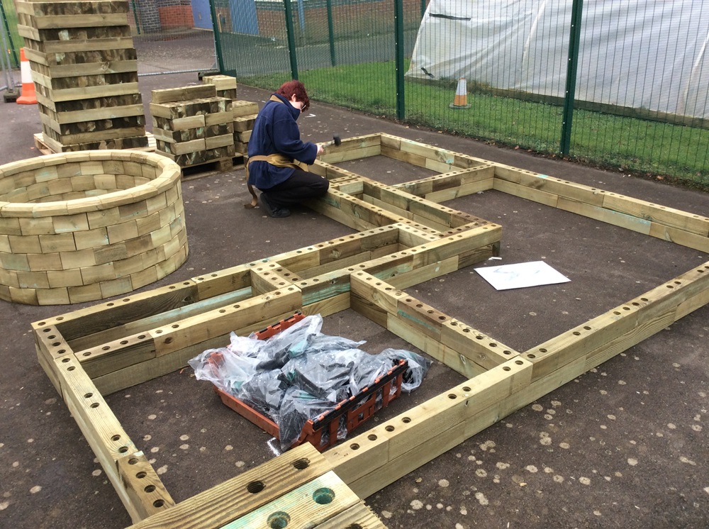 a pupil working on the L-shaped raised beds and seating area